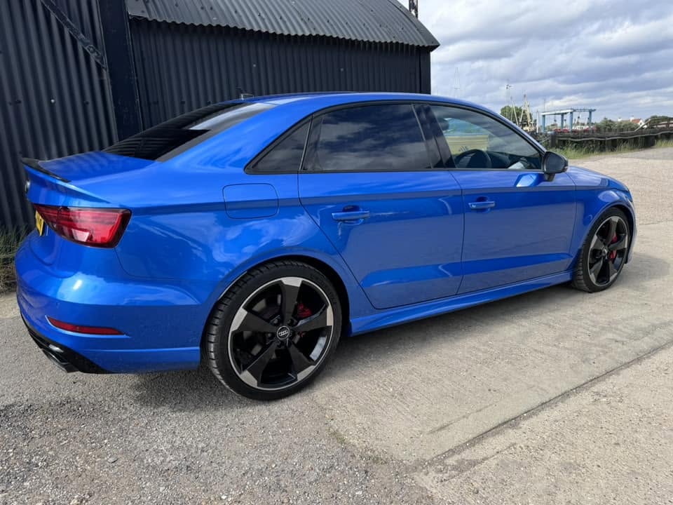 Rear three-quarter view of the blue Audi saloon