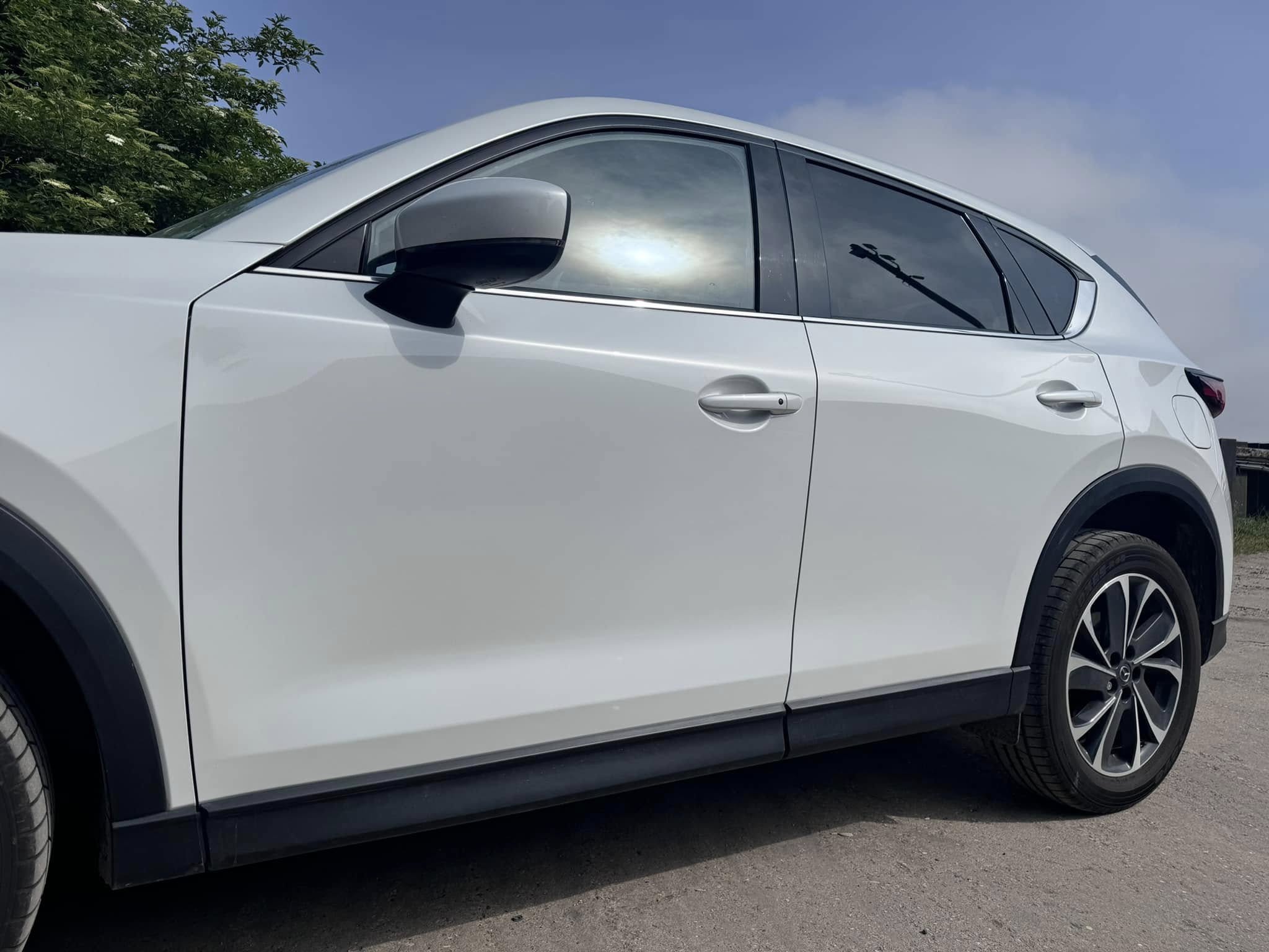 Side view of the white Mazda after its doors were refinished