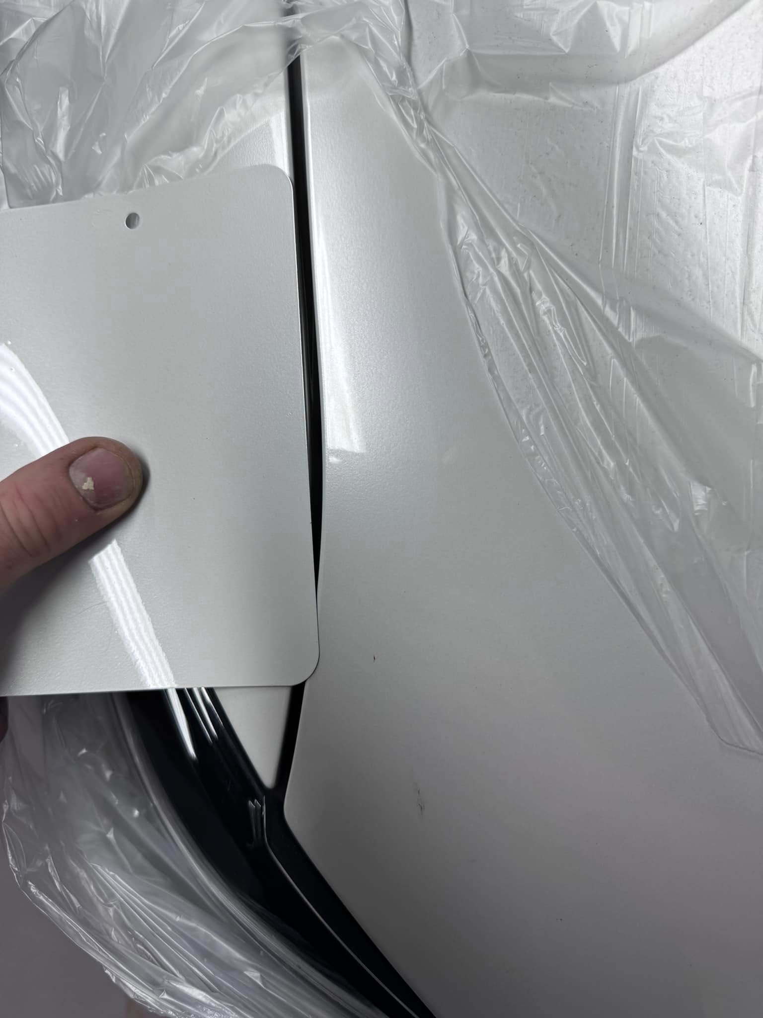 Colour test card held against a pearl white panel