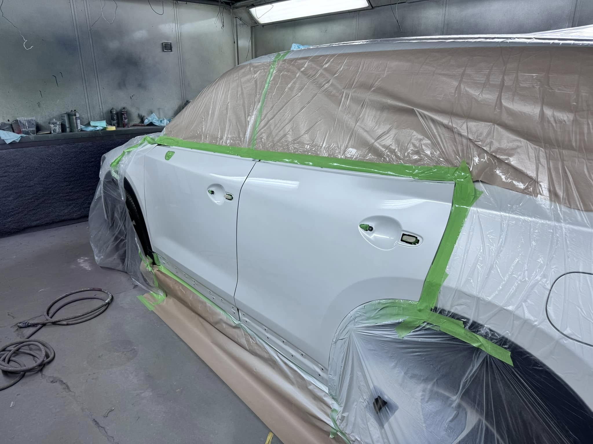 White Mazda masked up ready for paint in the workshop
