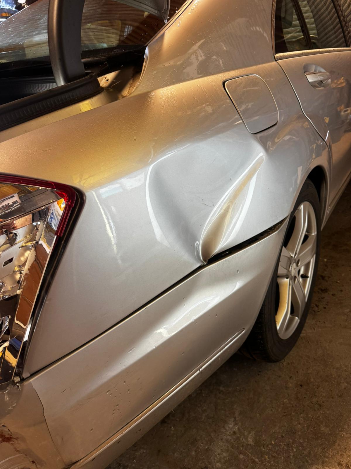 Silver Mercedes with a crumpled rear wing and door before repair