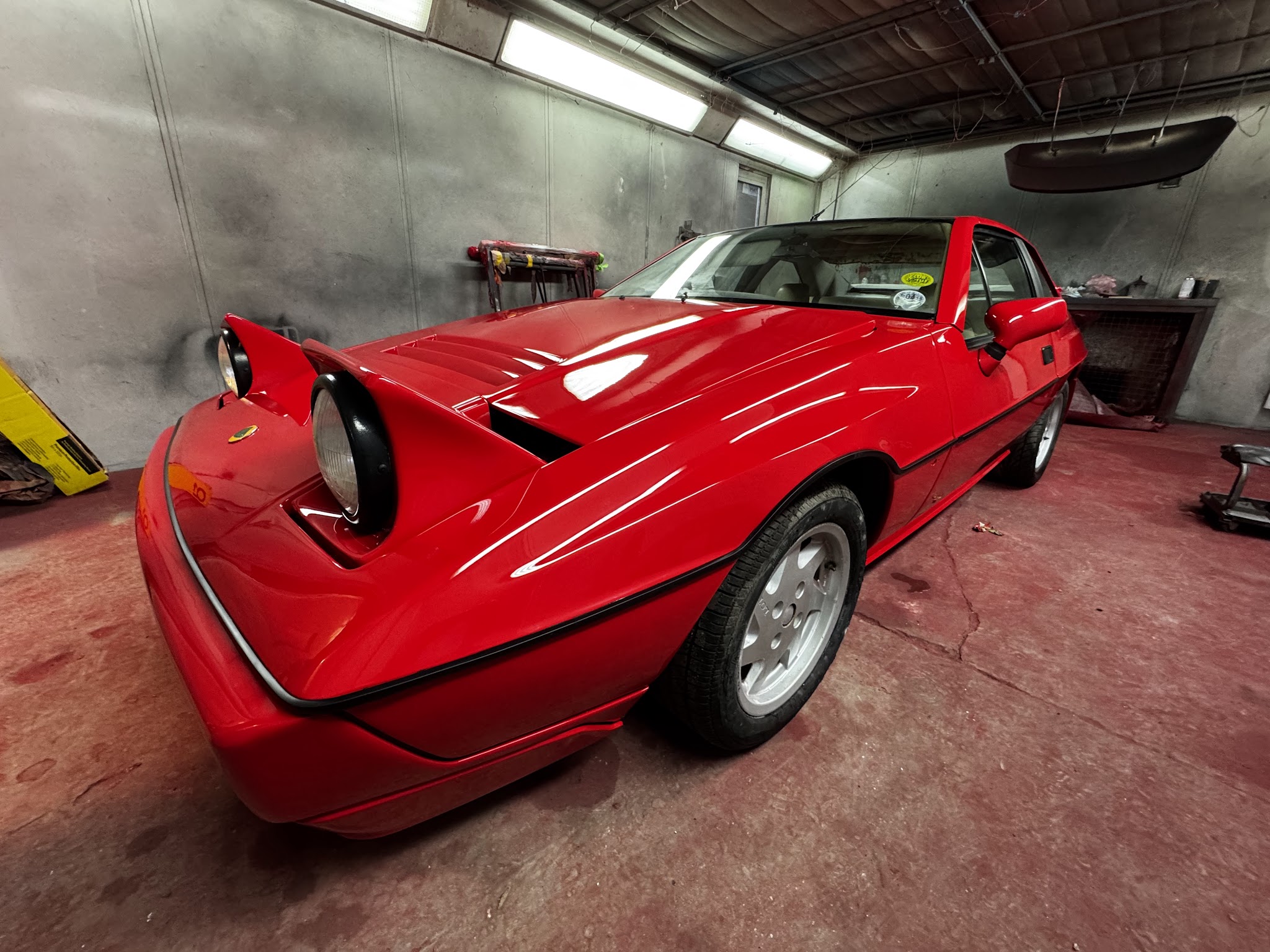 Red classic sports car inside the Autocorrect workshop