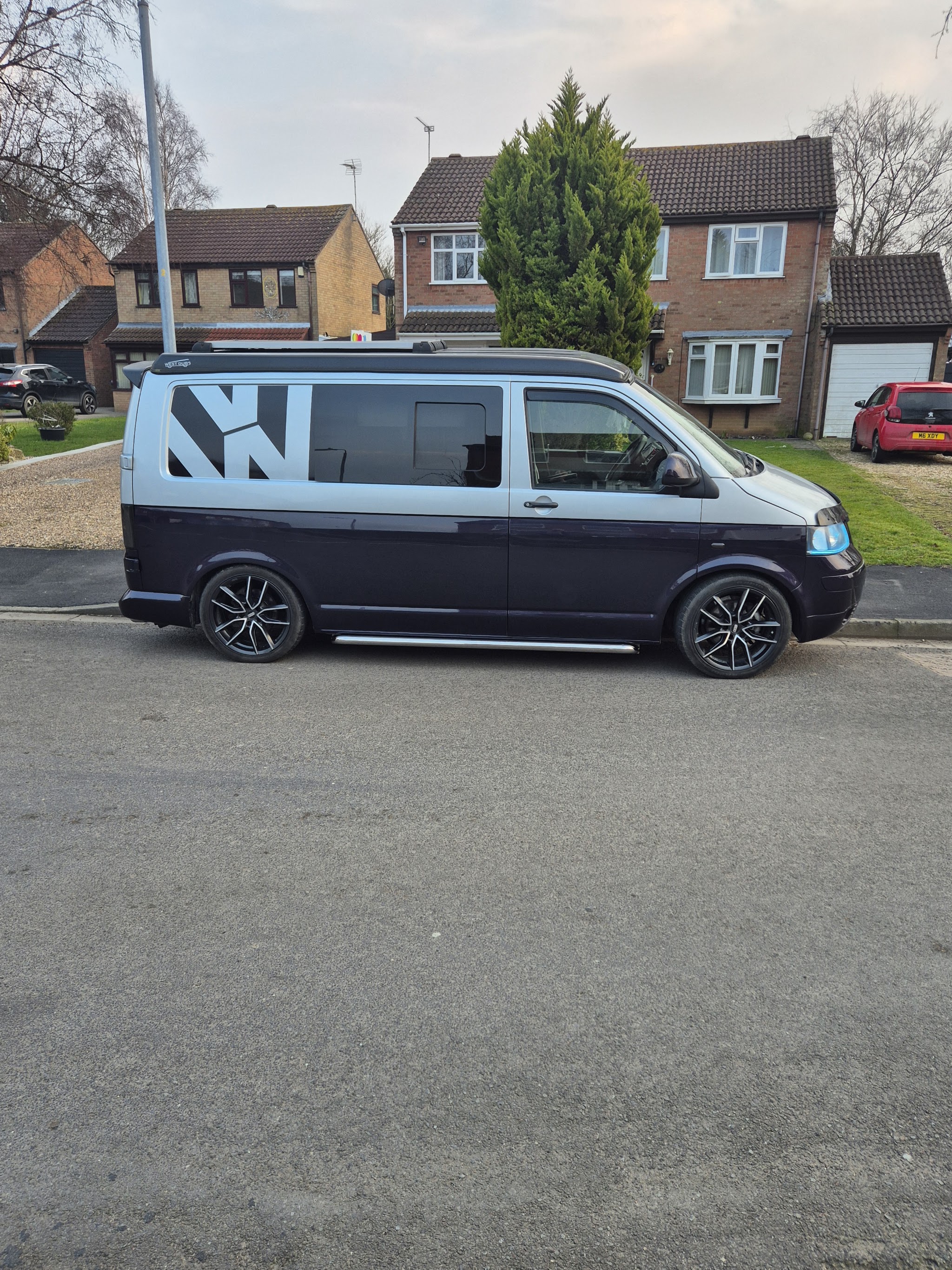 Two-tone VW camper van parked on a street